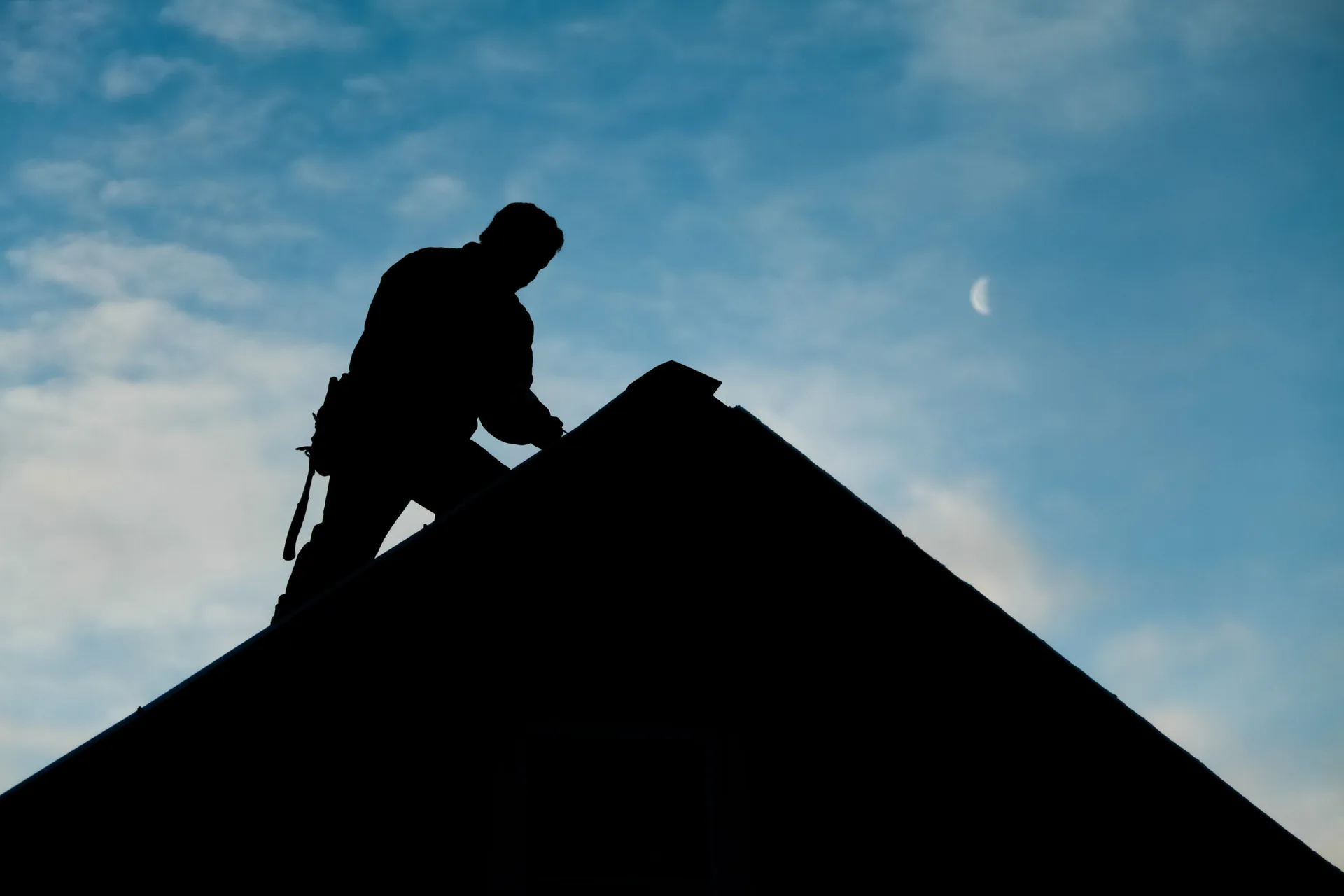 A roofing craftsman working above the Kansas skyline